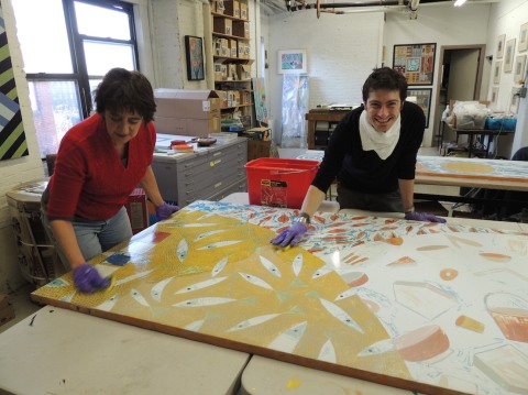 Rika Smith McNally and Rory Beerits of Cambridge Arts Council, cleaning the mural